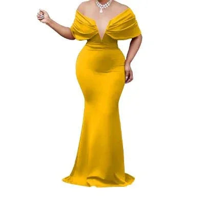 Woman in elegant yellow off-shoulder mermaid gown with deep neckline and necklace