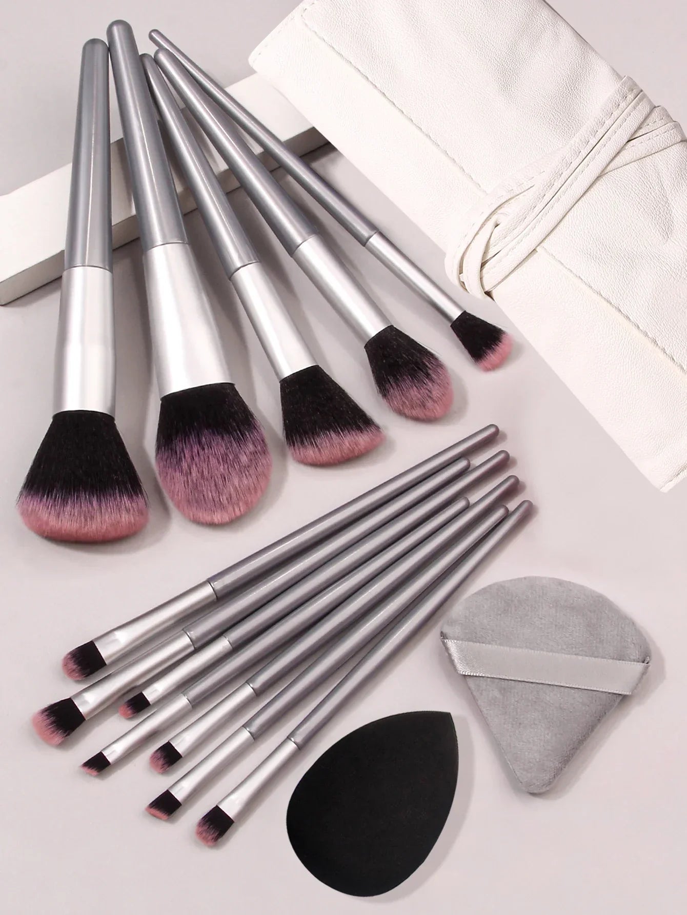 Luxury soft makeup brush set with silver handles, blending sponges, and white case
