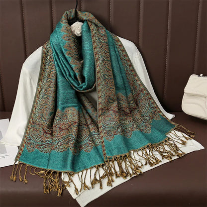 Elegant teal paisley pashmina scarf with gold fringe on brown leather chair