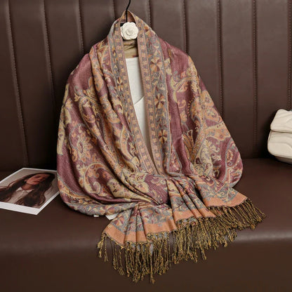 Paisley patterned pashmina shawl with fringe on brown leather bench, magazine and white purse nearby
