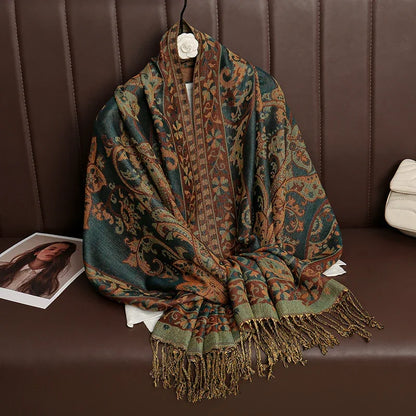 Paisley pattern shawl with fringed ends draped on brown leather sofa