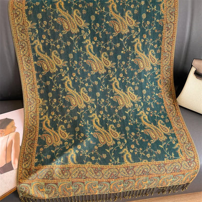 Green paisley pashmina shawl with gold and brown floral pattern on a sofa