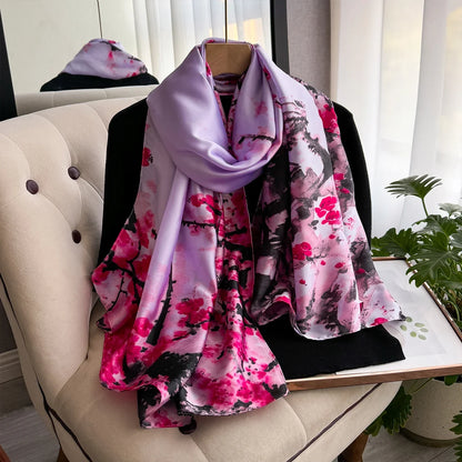 Silk scarf with pink cherry blossom print draped over a chair in a bright room