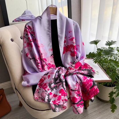Purple silk kimono with pink cherry blossom print draped on a chair by a window