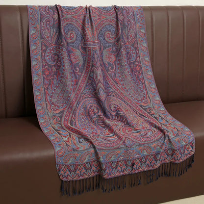 Paisley patterned red and blue shawl with fringe draped over a brown sofa