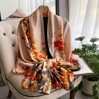 Silk floral kimono robe with orange and black print draped on a chair near a window