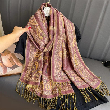 Pink and gold paisley scarf with fringe displayed on a black shirt