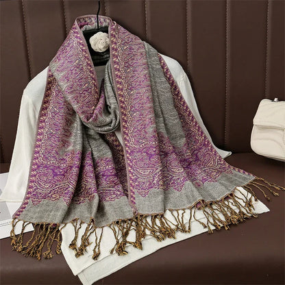 Purple and gray paisley shawl scarf with tassels draped on a white sweater