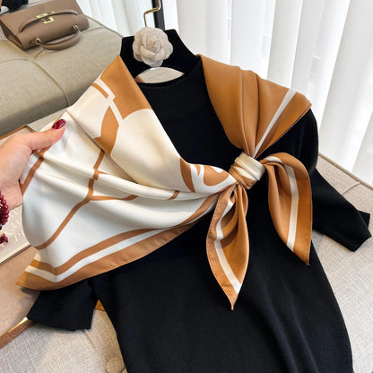 Elegant brown and white silk scarf tied on a black sweater, luxury fashion accessory display