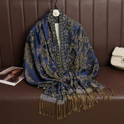 Blue and gold paisley jacquard scarf with fringe, displayed on brown leather sofa