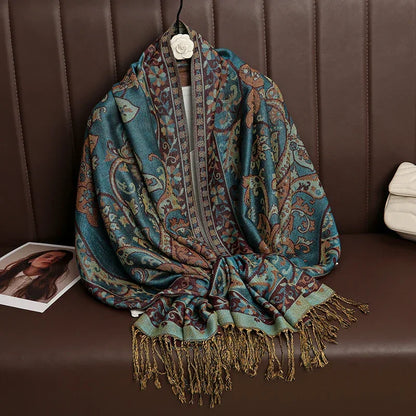 Bohemian paisley scarf with teal and gold fringe draped on a brown leather couch