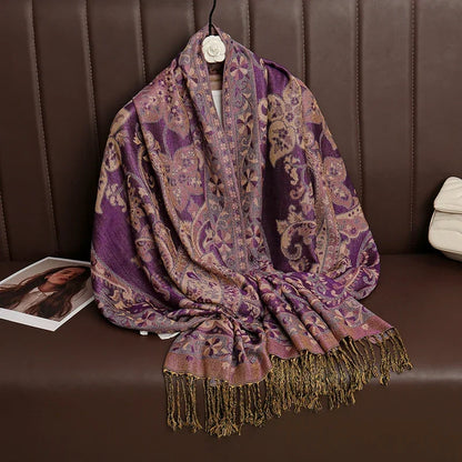 Purple paisley patterned pashmina scarf with gold fringe on brown sofa