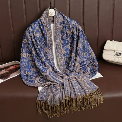 Blue gold paisley scarf with fringe on brown bench, next to white purse and magazine