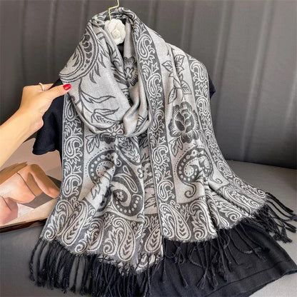 Gray paisley floral shawl with black fringe, draped on a black top