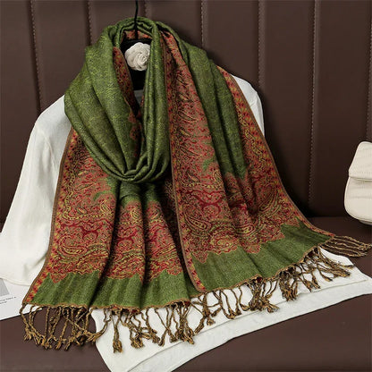 Green and red paisley patterned scarf with tassels draped on a white chair