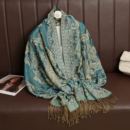 Blue and gold paisley pattern shawl with fringe on brown leather bench, fashion accessory
