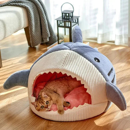 Cat relaxing in a shark mouth pet bed for cats and small dogs on wooden floor