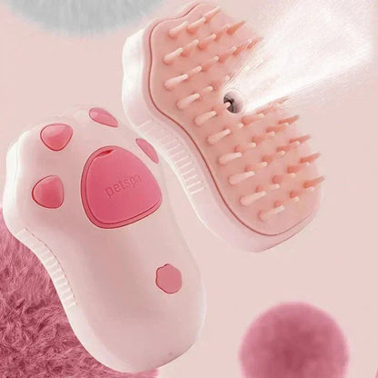 Pink steam grooming brush for cats and dogs shaped like a paw, spraying mist