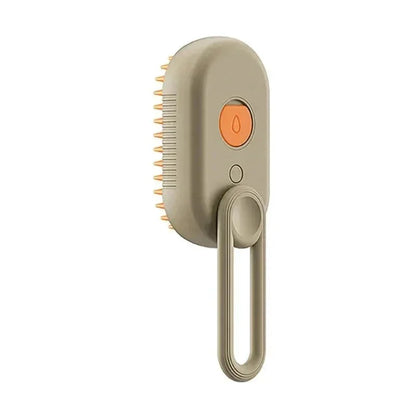 Beige steam grooming brush for cats and dogs with orange button and loop handle