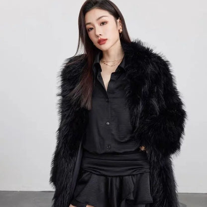 Woman wearing black faux fur winter coat over black shirt and skirt against plain background