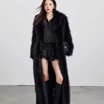 Woman wearing long black faux fur winter coat with black blouse, skirt, and knee-high boots in studio