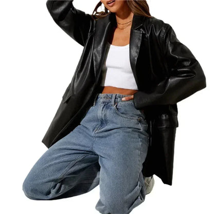 Woman wearing black luxury vintage faux leather blazer, white crop top, and blue jeans