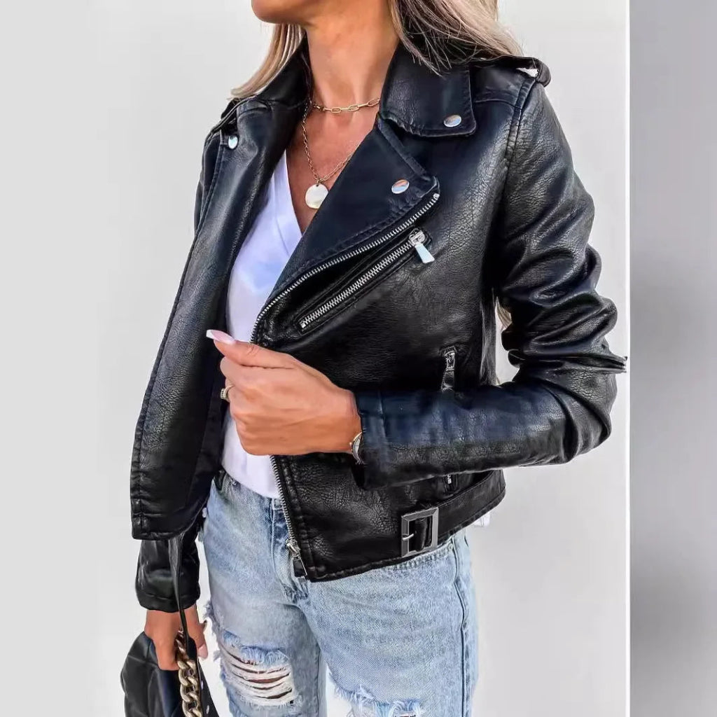 Woman wearing luxury slim fit black PU leather jacket with silver zippers and ripped jeans