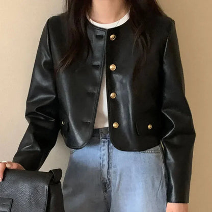 Black vintage leather jacket with gold buttons worn over white top and light blue jeans