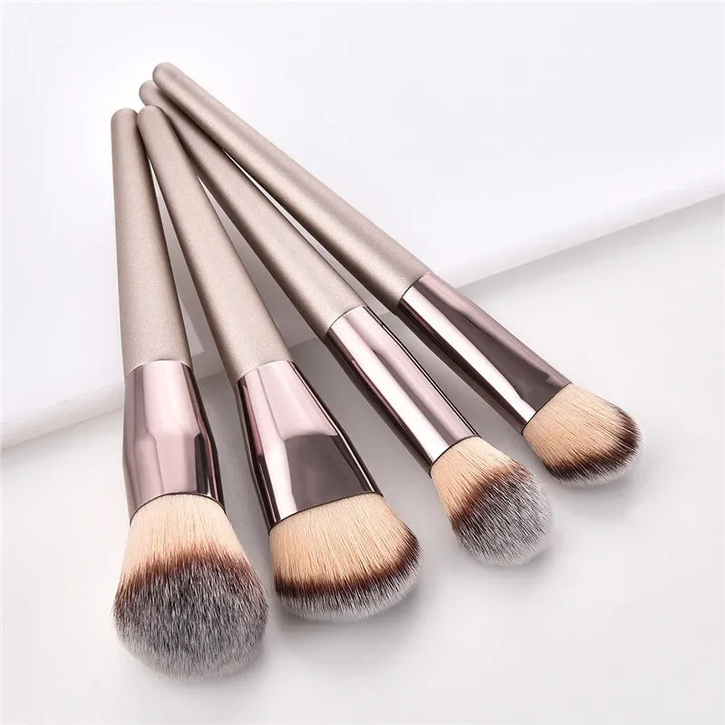 Champagne luxury makeup brush set with metallic handles on a white background