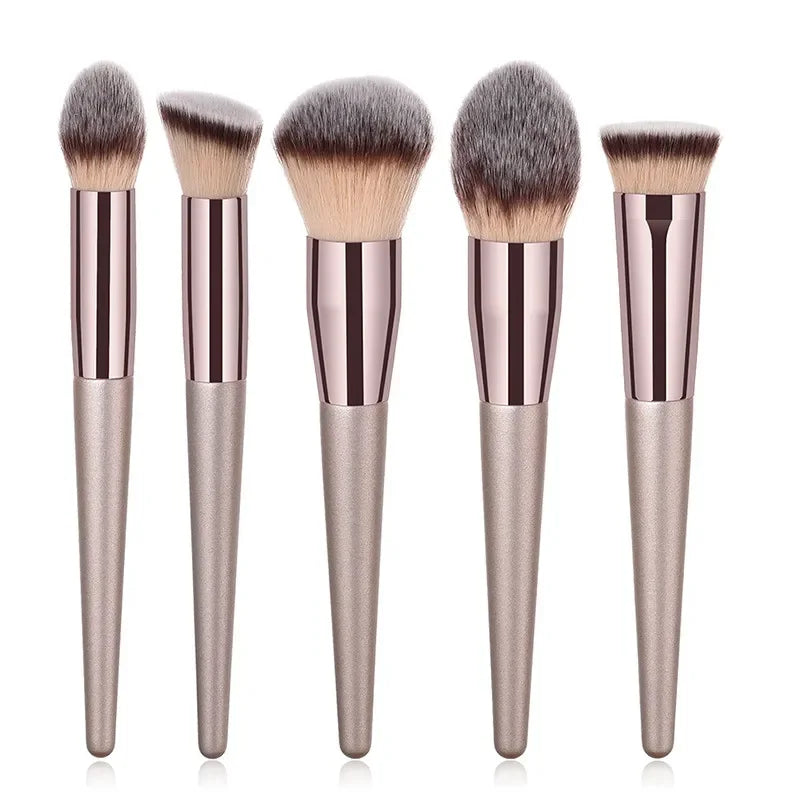Champagne luxury makeup brush set with five metallic brushes on a white background