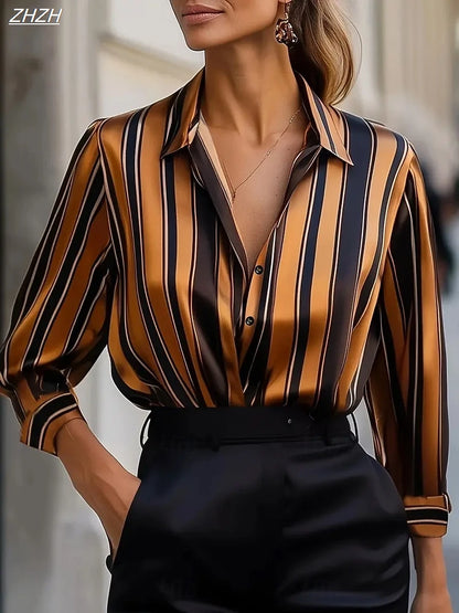 Woman wearing geometric striped slim blouse with black and gold vertical stripes, paired with black pants