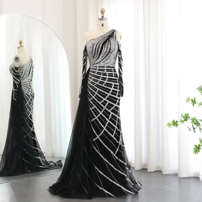 Black luxury beaded mermaid gown with silver intricate patterns, one-shoulder design, and long sleeves on mannequin