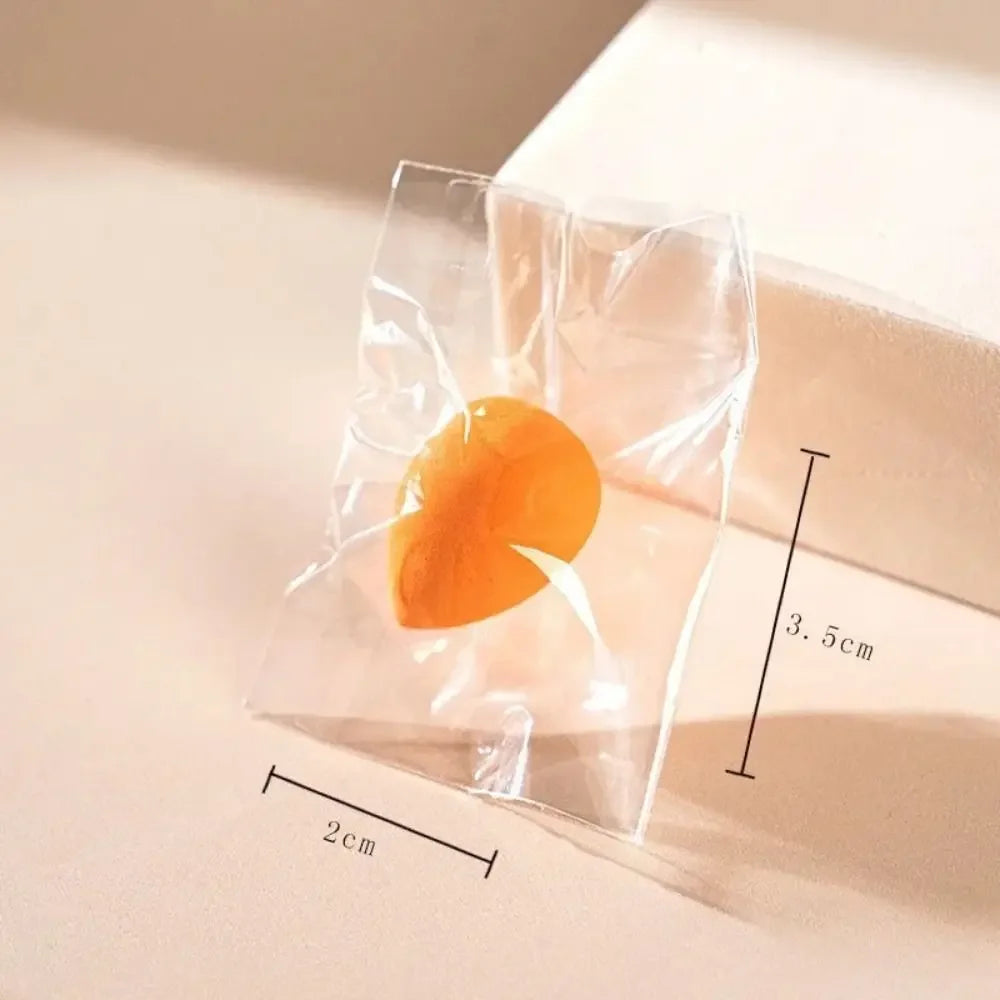 Orange luxury makeup sponge in transparent packaging with 2cm by 3.5cm dimensions shown