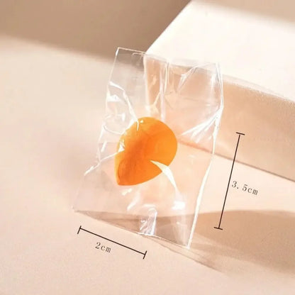 Orange luxury makeup sponge in transparent packaging with 2cm by 3.5cm dimensions shown