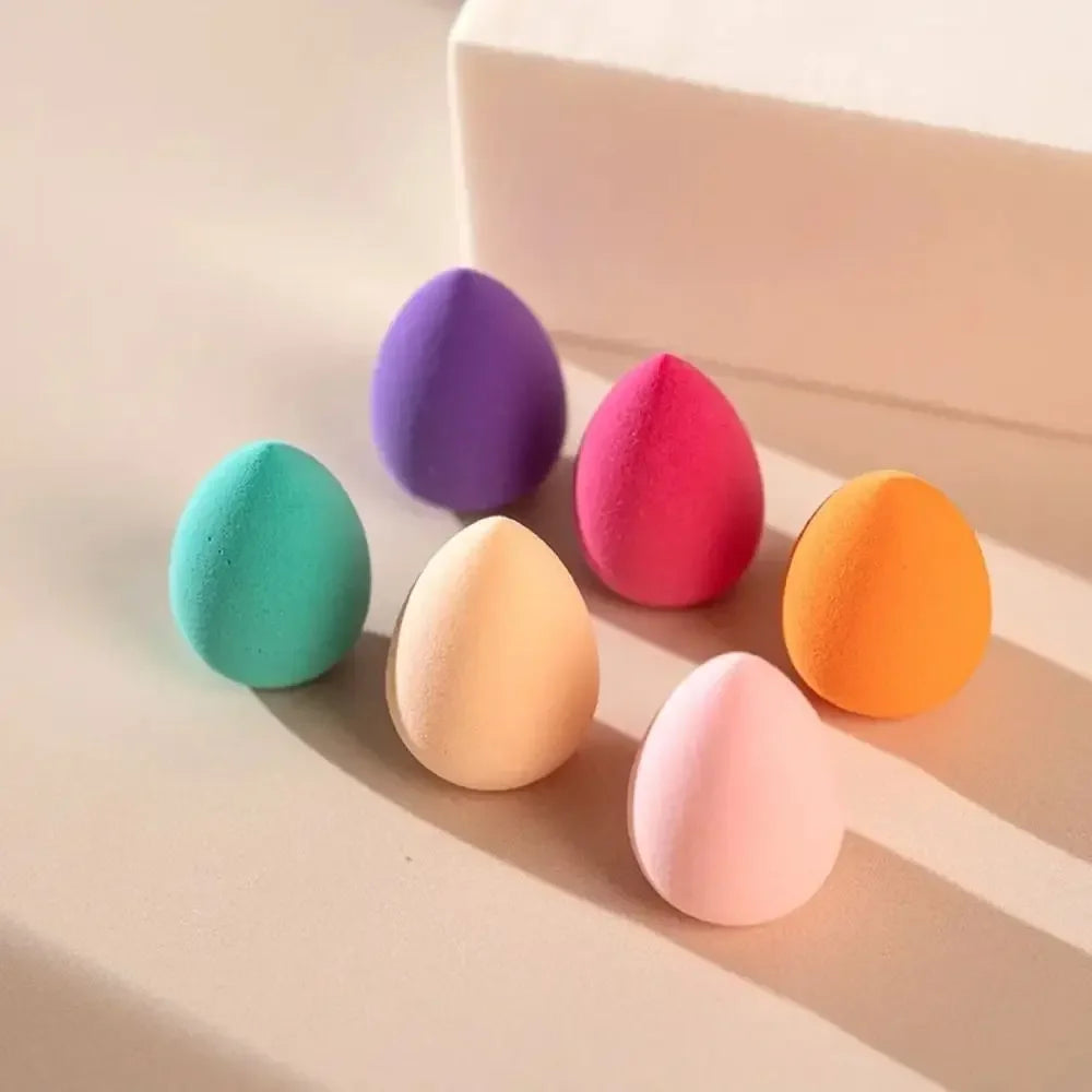 Set of six colorful luxury makeup sponges on a neutral background