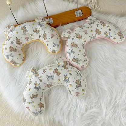 Three U-shaped luxury pet pillows with cute bear and balloon prints on white faux fur background