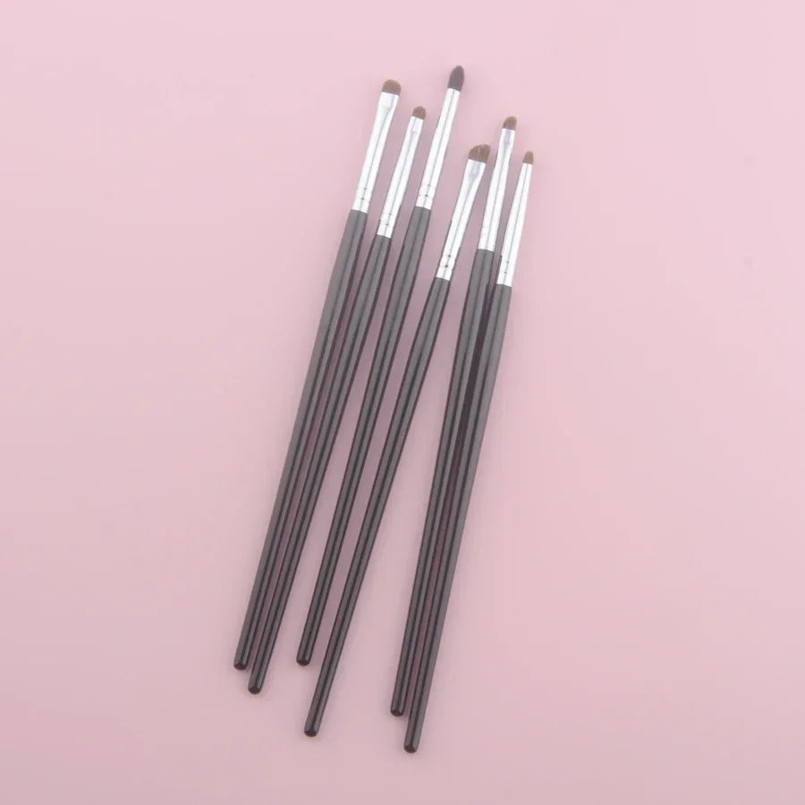 Luxury pony hair eyeshadow brushes with dark handles on a pink background