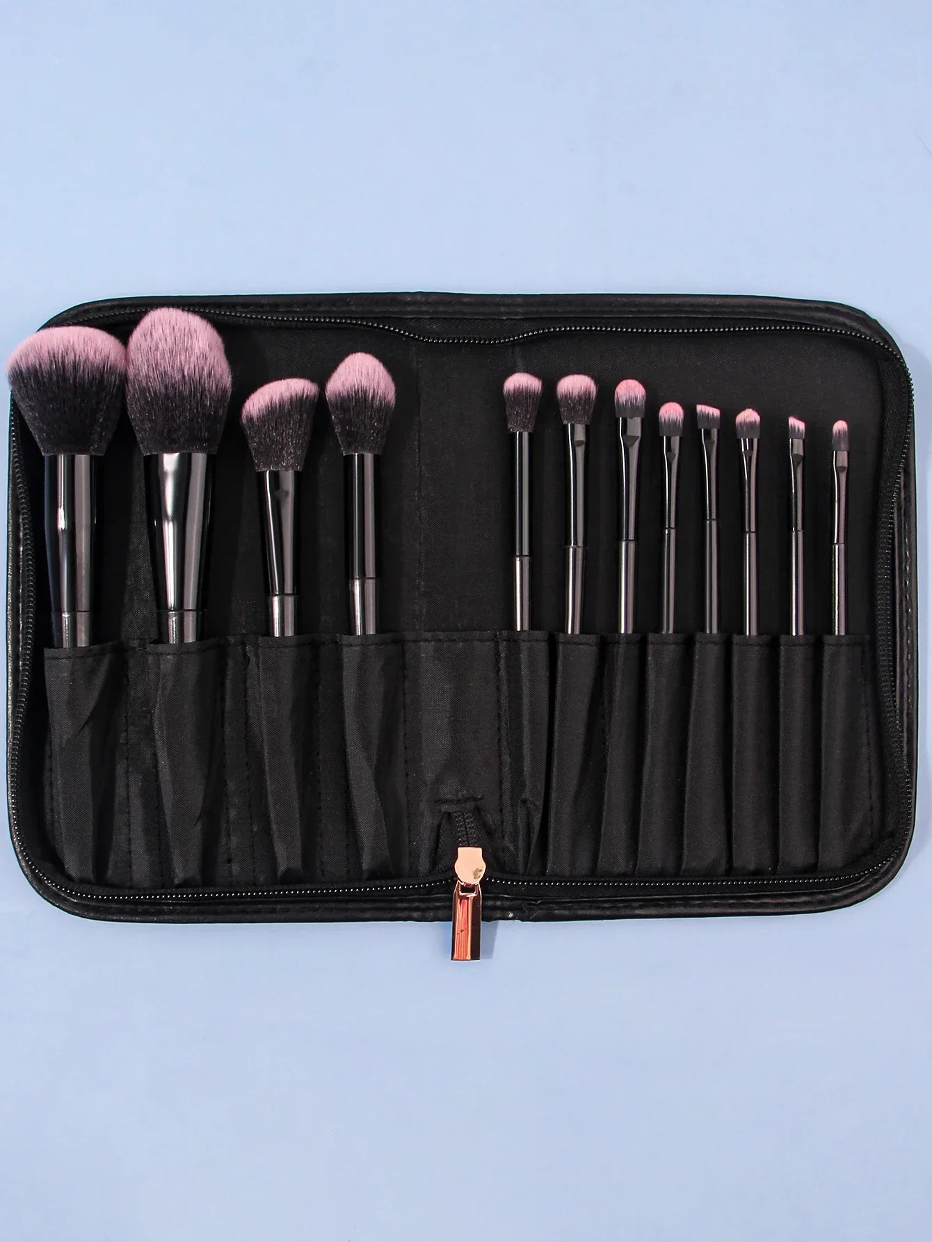 Luxury soft makeup brush set of 12 in black zippered case on light blue background