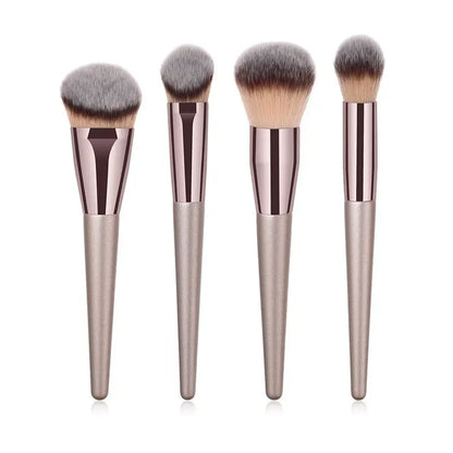 Champagne luxury makeup brush set with four soft, metallic-handle brushes on white background.