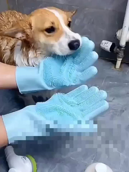 Wet dog being groomed with blue silicone pet grooming gloves on gray tiled floor