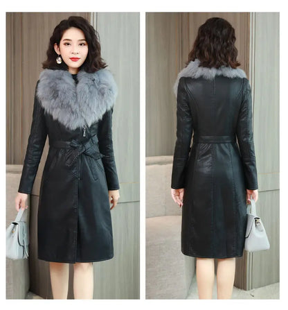 Woman wearing black PU leather long coat with gray faux fur collar and waist tie, holding a light gray handbag