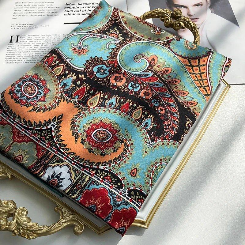 Colorful paisley silk scarf folded on ornate frame and magazine in sunlight