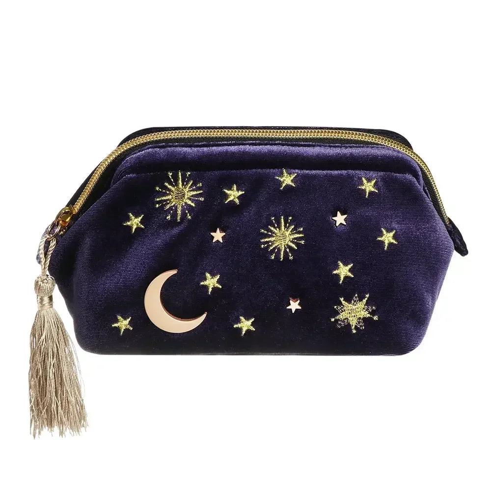 Velvet embroidered portable cosmetic bag with gold embroidered stars, moon, and tassel zipper.